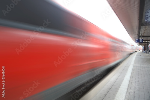 Fast moving red train at the station