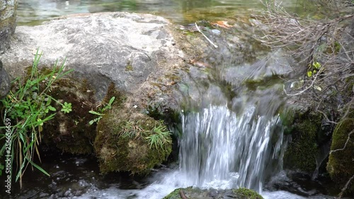 Flowing water stream, water drops and reflection