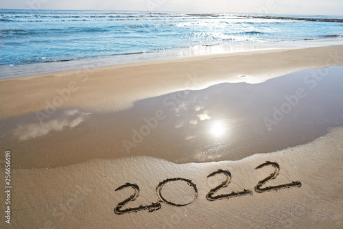 year 2022 numbers spell written on beach