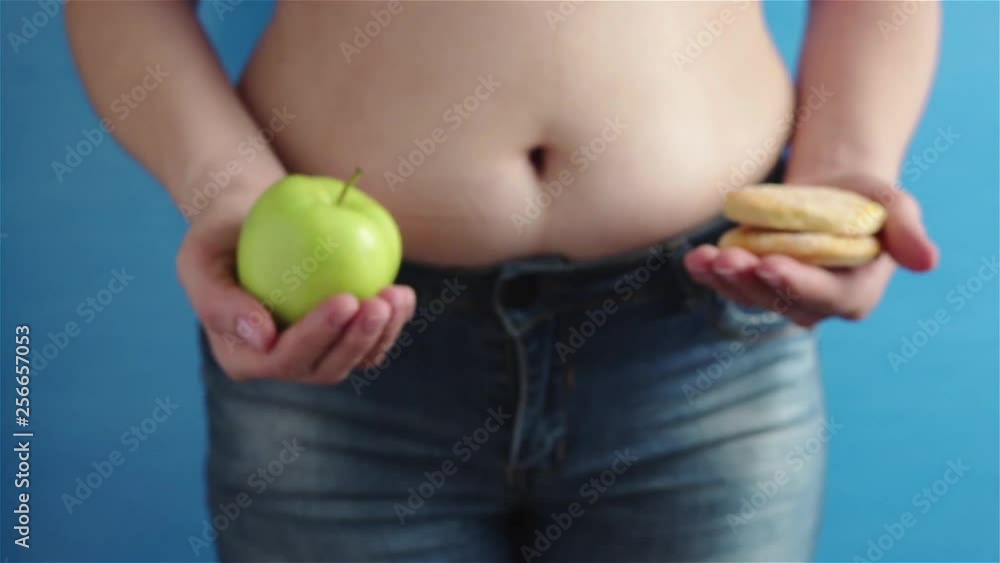 obese woman choising healthy food green apple or cookie close up obese woman choising healthy food green apple or cookie close up