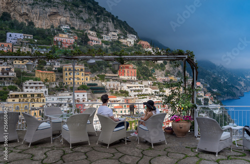 Romantic couple on balcony over view of Positano town at Amalfi Coast, Italy.