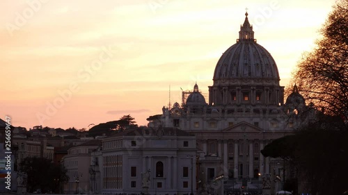 Rome, dramatic orange sunset behind the Vatican Dome with birds flying