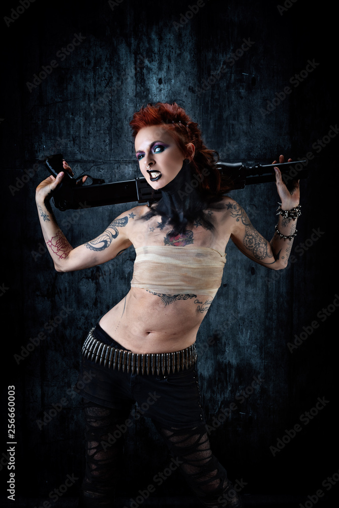 Young tattooed woman, one-eyed, rifle in his hands
