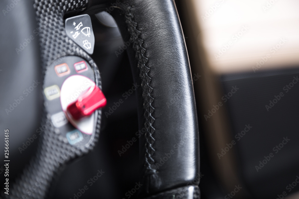 Close up of stitching on black leather car steering wheel