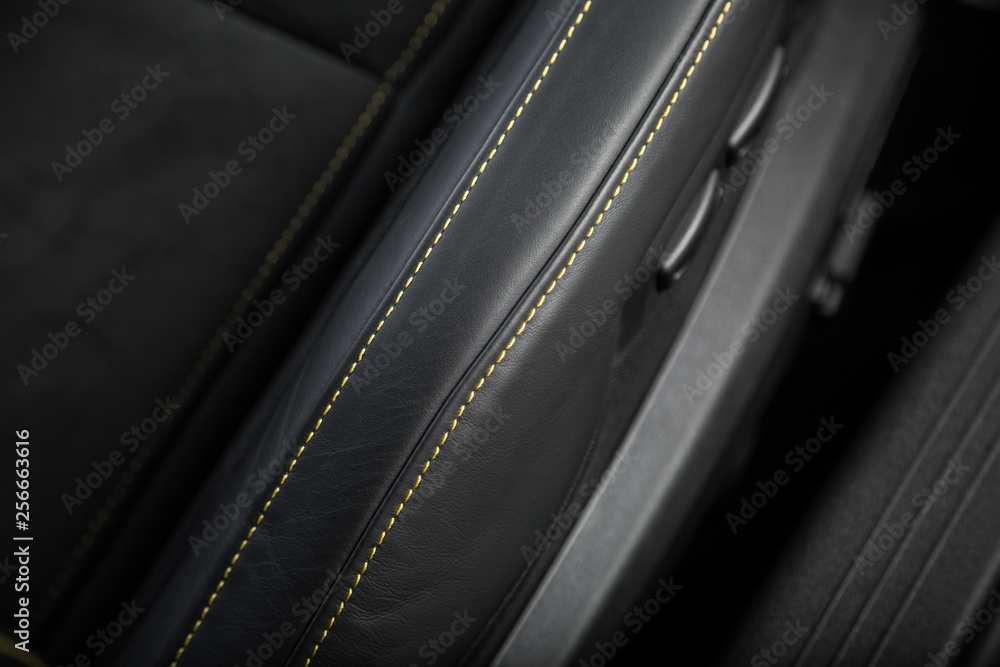 Yellow contrast stitching on black leather car seat Yellow contrast stitching on black leather car seat