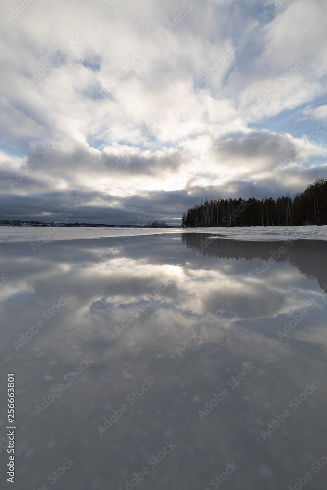 Obraz premium Sky reflection from wet ice surface at lake