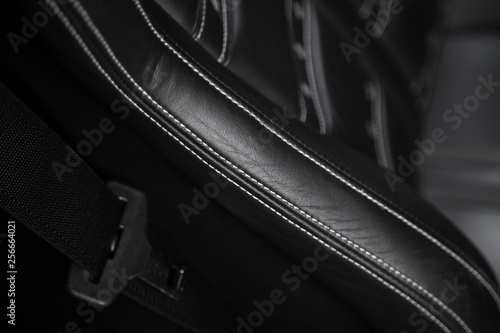 Close up of contrast stitching on black leather car seat