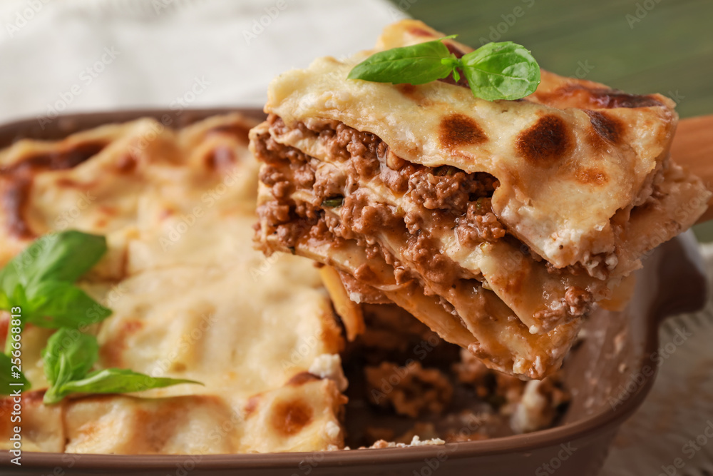 Taking of piece of tasty lasagna from casserole, closeup Taking of piece of tasty lasagna from casserole, closeup