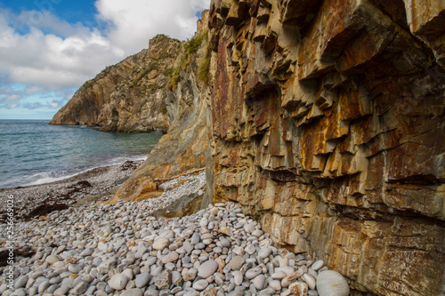 Weißer Kiesstrand und farbiges Gestein der schroffen Felsküste am Strand Playa del Silencio in Asturien, Nordspanien