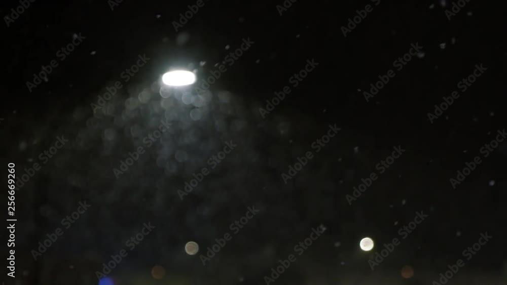 Snow falling in slow motion at 120 fps at night in front of a city street light Snow falling in slow motion at 120 fps at night in front of a city street light