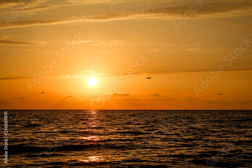 Golden, Fiery sunset on the Black Sea, on the beach. Coast, stones, waves, sun, beautiful sky, clouds. August, Batumi, Georgia. Water, ease, game. plane in the sky, tourism © Sea_Inside_Soul