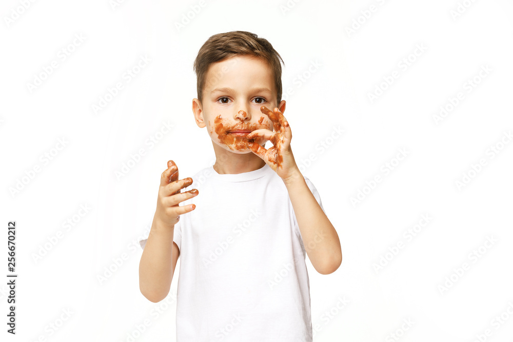 little boy with face and hands in chocolate little boy with face and hands in chocolate