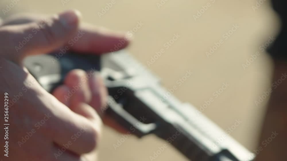 Inserting magazine into pistol at shooting range Inserting magazine into pistol at shooting range