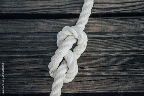 Ship rope knot on wooden background