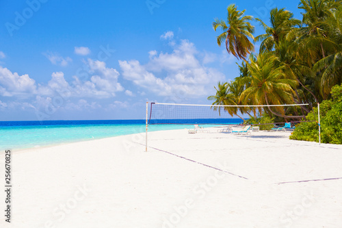 Fototapeta Naklejka Na Ścianę i Meble -  Vacation summer sport holidays background wallpaper - sunny tropical Caribbean paradise beach with white sand on Maldives island Thailand style with palms and volleyball net sunbed