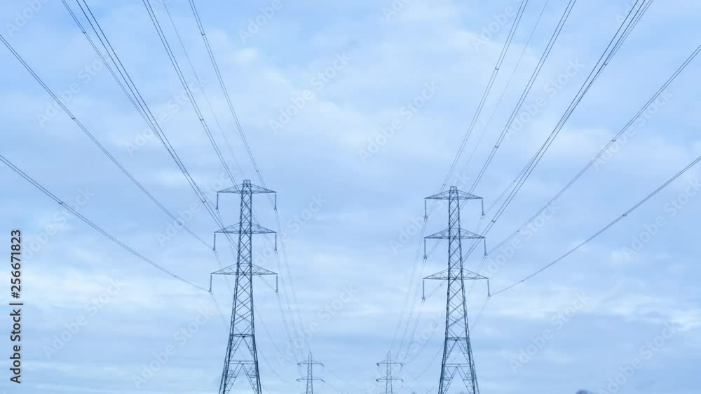 Timelapse of electricity pylons against a stormy sky themes of electricity