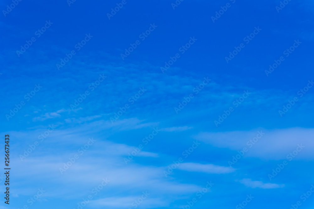 Horizontal photo of winter blue clear sky background with white layered clouds without sun