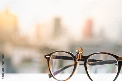 Miniature of a women and a man in love sitting on glasses with city backgrounds, couple in love and pre-wedding background concept
