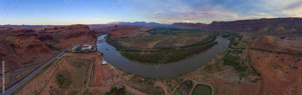 Aerial view of Colorado River and La Sal Mountains panorama at sunset near Arches National Park in Moab, Utah, USA.