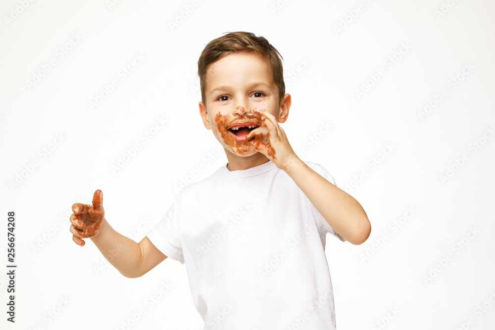little boy with face and hands in chocolate little boy with face and hands in chocolate