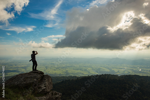 Man standing on top mountain and looking sunset. © nidsornkul1989