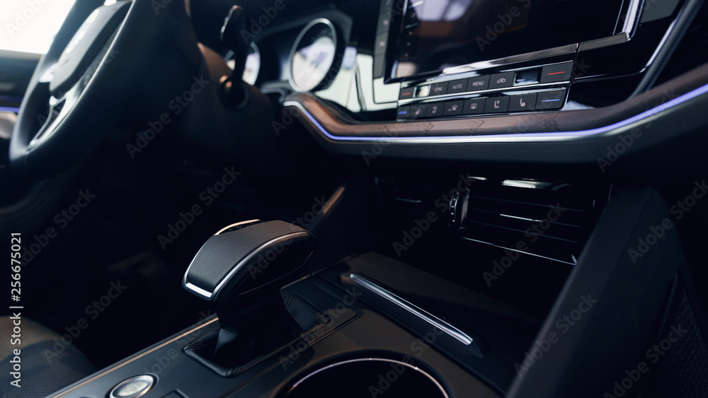 Car interior. Modern car illuminated dashboard. Luxurious car instrument cluster. Close up shot of automobile instrument panel. Modern car interior dashboard and steering wheel