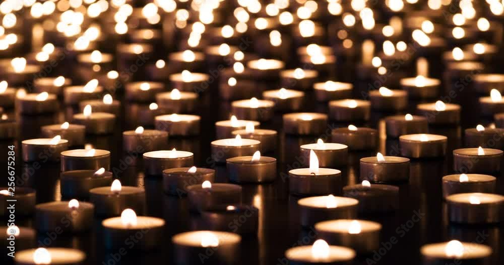 Candles of Memory. A large field of lit small candles on a dark granite surface. The air is slowly waving lights. Filmed at a speed of 120fps Candles of Memory. A large field of lit small candles on a dark granite surface. The air is slowly waving lights. Filmed at a speed of 120fps
