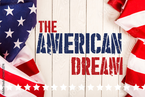 top view of american flags and the american dream lettering on white wooden surface