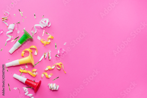Colorul party streamers on pink background. Celebration concept. Flat lay.