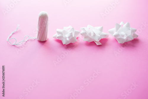Medical female tampon on a pink background. Hygienic white tampon for women. Cotton swab. Only one tampon on a pink background. copy space © Nastya