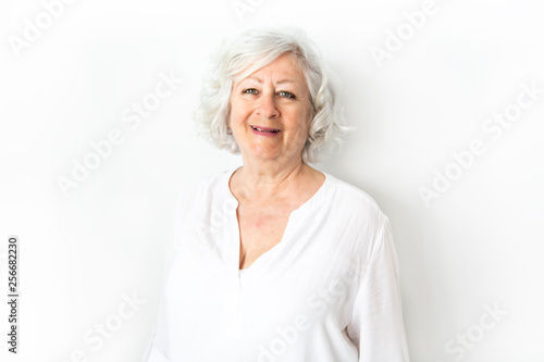 A Senior woman studio isolated on grey wall laughing cheerful