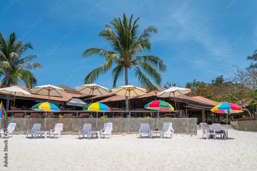 Colorful umbrella with sunbed on white beach