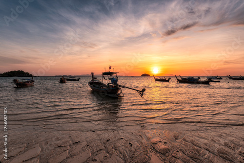 Wooden long-tail boats on tropical sea at sunrise morning beach