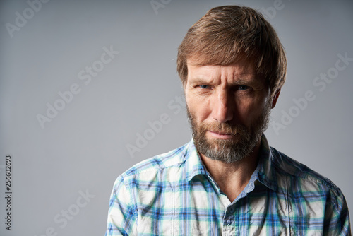 Obraz na plátně Studio portrait of smiling mature man in checkered shirt