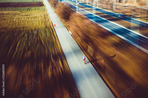 Aerial cyclist sunny day at bicycle path travel with motion