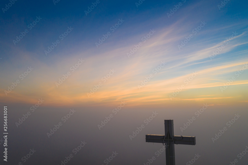 Foggy cross church sunrise morning with beautiful colours. Clouds with natural colors.