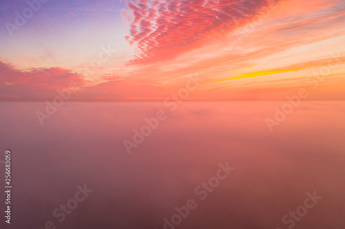 Foggy sunrise morning with beautiful colours. Clouds with natural colors.