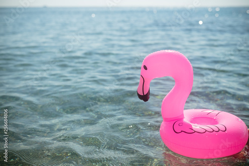 Pink flamingo inflatable on the background of the sea.having fun in the pool or in sea on an inflatable pink flamingo in a bathing suit in summer.Beach and water fun.summer vacation.Inflatable float © Yulia