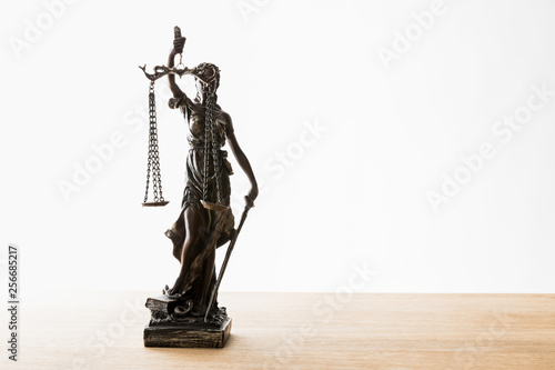 bronze statuette with scales of justice on wooden surface isolated on white with copy space