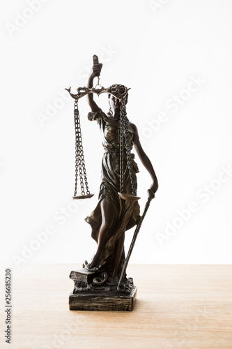 bronze statuette with scales of justice on wooden surface isolated on white