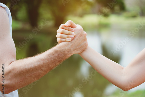 Handshake between men and women represents equality of living in society. It is a commitment to the promise of protecting when needing help, or having a health insurance concept.