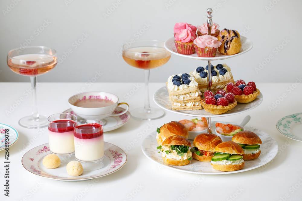 Afternoon tea with mini brioche canapes and selection of sweets Photos |  Adobe Stock