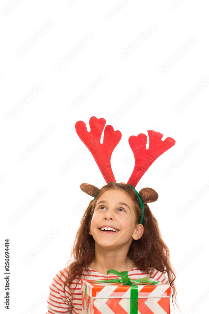 Little Santa girl in a Christmas hatertical shot of a pretty young curly haired girl wearing raindeer antlers laughing joyfully holding her Christmas present looking at copyspace above her isolated Little Santa girl in a Christmas hatertical shot of a pretty young curly haired girl wearing raindeer antlers laughing joyfully holding her Christmas present looking at copyspace above her isolated