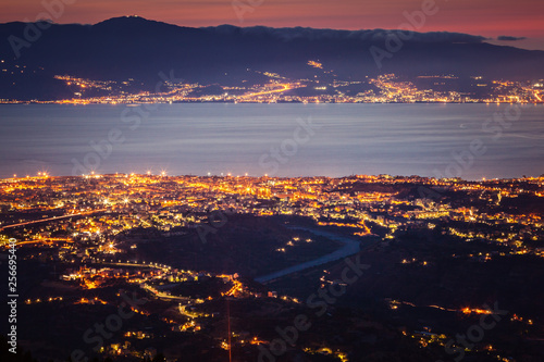 Messina strait and Reggio Calabria city lights at dusk photo