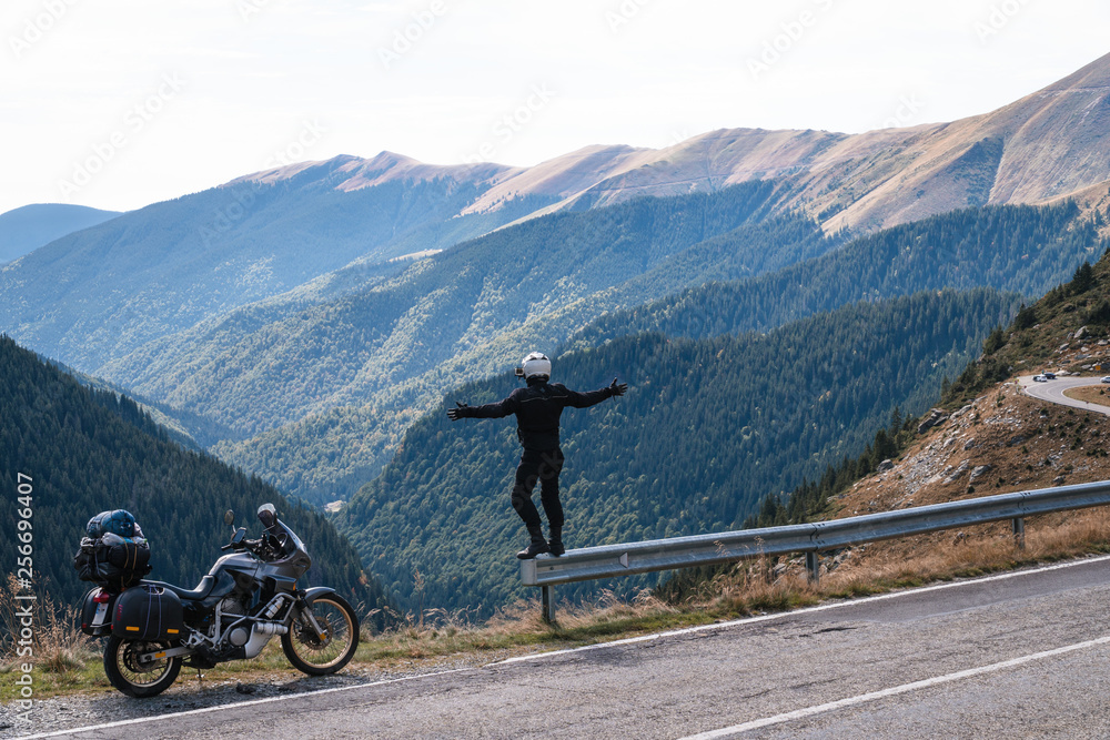 motorcycle rider enjoy the momment. raised arms. adventure motorbike on the top mountain, enduro, off road, beautiful view, danger road in mountains, freedom, extreme vacation. Transfagarasan Romania