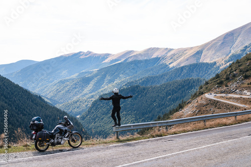 motorcycle rider enjoy the momment. raised arms. adventure motorbike on the top mountain, enduro, off road, beautiful view, danger road in mountains, freedom, extreme vacation. Transfagarasan Romania photo