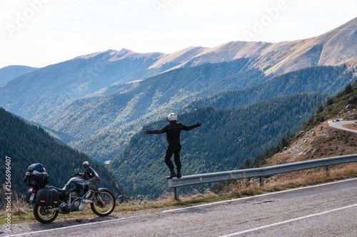 motorcycle rider enjoy the momment. raised arms. adventure motorbike on the top mountain, enduro, off road, beautiful view, danger road in mountains, freedom, extreme vacation. Transfagarasan Romania © Sergey