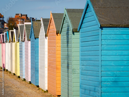 row of multi-colored huts on beach in summer
