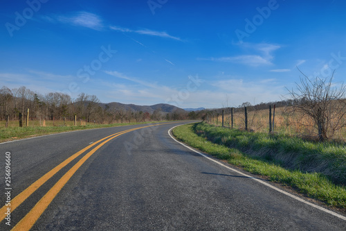  Curving  wide angle curved road through the piedmont of the blue ridge mountains mid day sun ZDS On the Road Collection