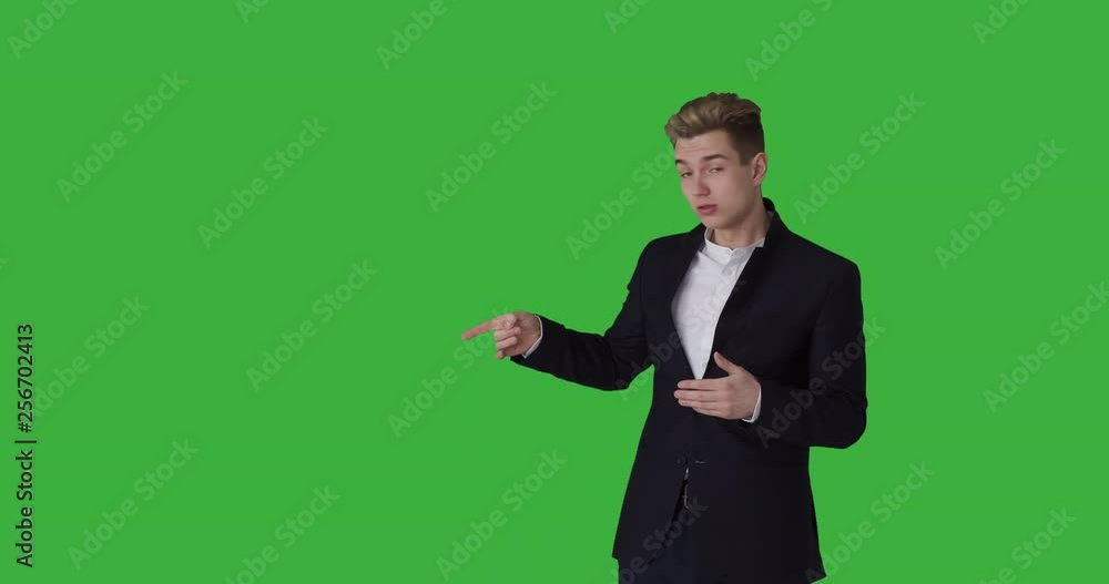 Businessman pointing at blank green screen during presentation Businessman pointing at blank green screen during presentation